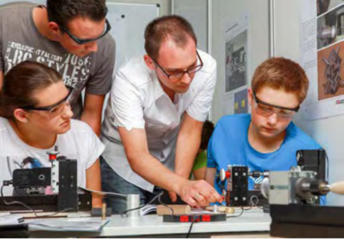 Students and teacher working with the UNIMAT MetalLine lathe, teacher explains the functions of the lathe