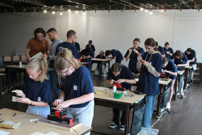 Large group of students works with the UNIMAT machines in a crafting competition